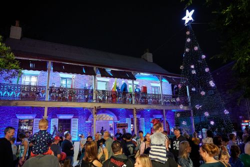 Picture of Loder House lit up next to a Christmas tree at Light Up Windsor