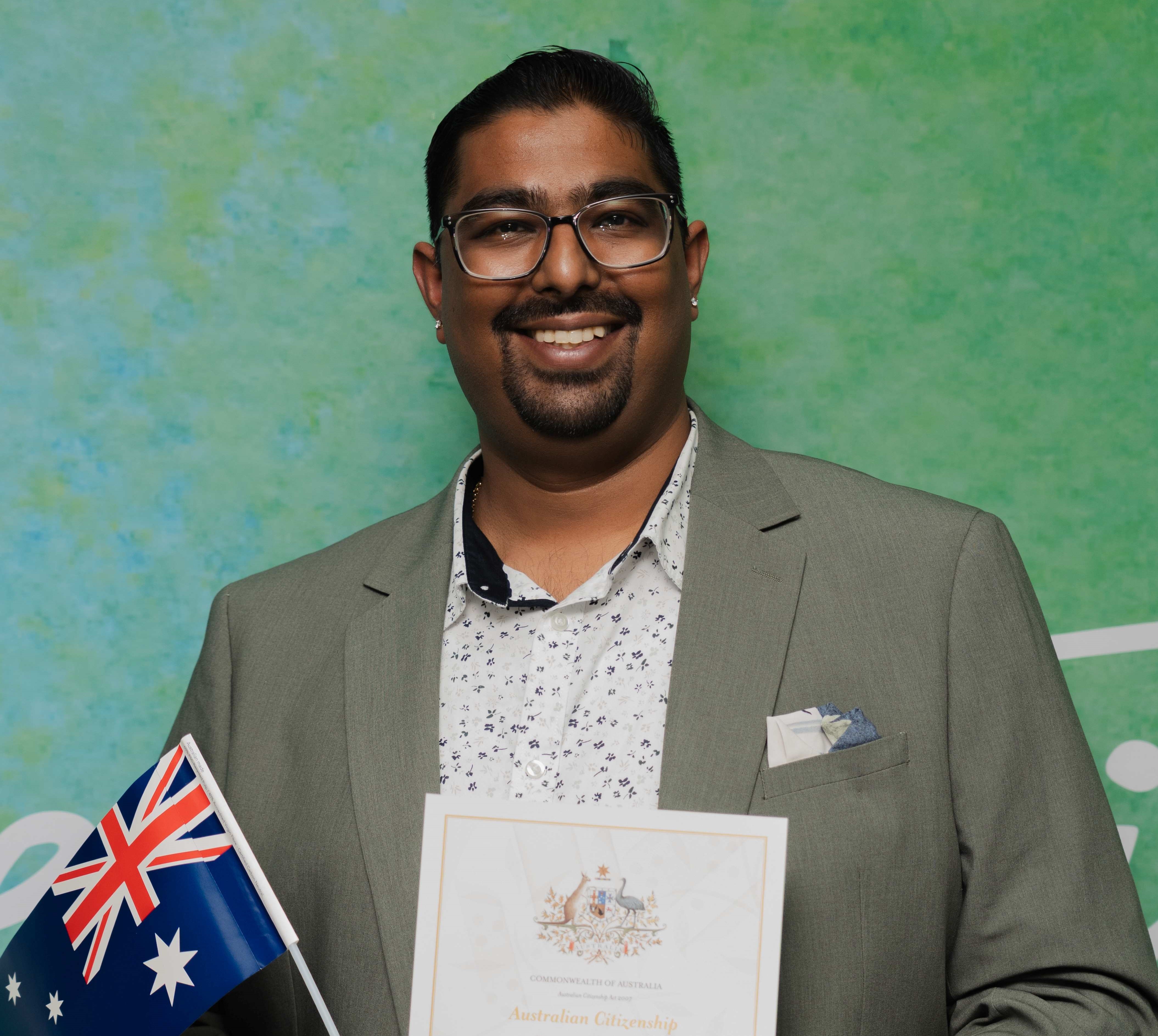 A new citizen holding a flag and certificate