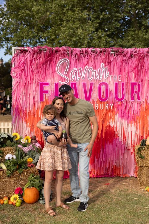 Image of a family in front of the Savour the Flavour wall